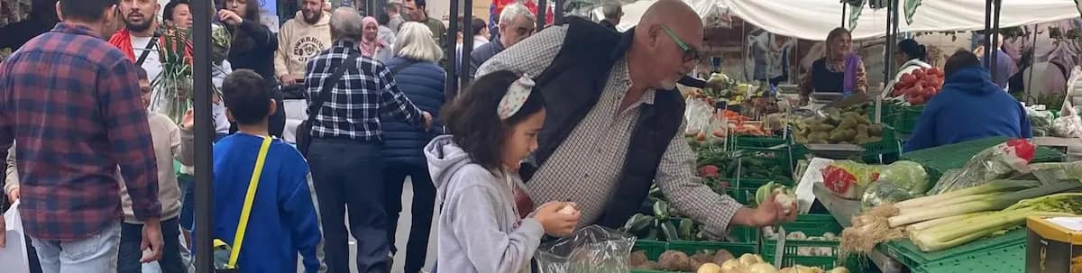 At a local market in Spain, selecting produce from a market stall.