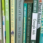 Banner image of a bookshelf with books in a gold colour on the left, transitioning through green to blue on the right. DeskSpace business books.