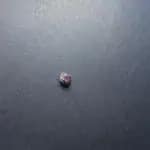 An unpolished garnet on a black background, photographed by me.